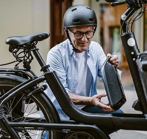 Mann entnimmt E-Bike Akku aus Fahrrad