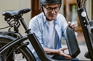 Mann hält E-Bike Akku in den Händen